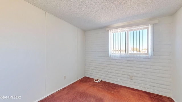 empty room with carpet floors and a textured ceiling