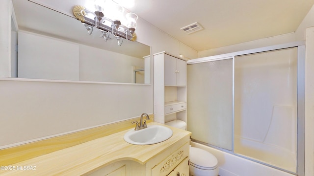 bathroom featuring toilet, shower / bath combination with glass door, vanity, and visible vents