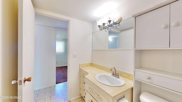 bathroom with toilet, tile patterned floors, baseboards, and vanity