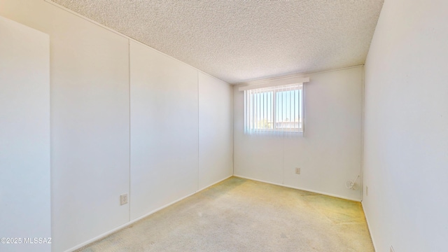 unfurnished room with a textured ceiling and light colored carpet