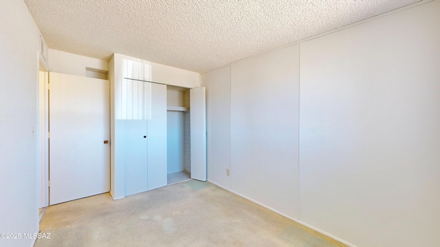 unfurnished bedroom featuring carpet, a closet, and a textured ceiling