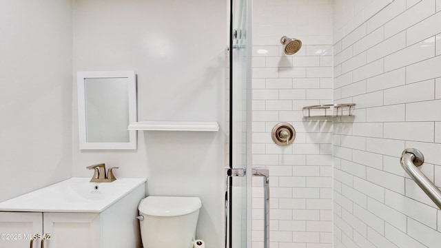 full bathroom with tiled shower, vanity, and toilet