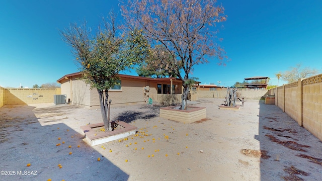 rear view of property featuring central AC and a fenced backyard