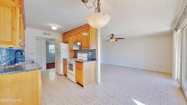 kitchen featuring white appliances, visible vents, light floors, under cabinet range hood, and a sink