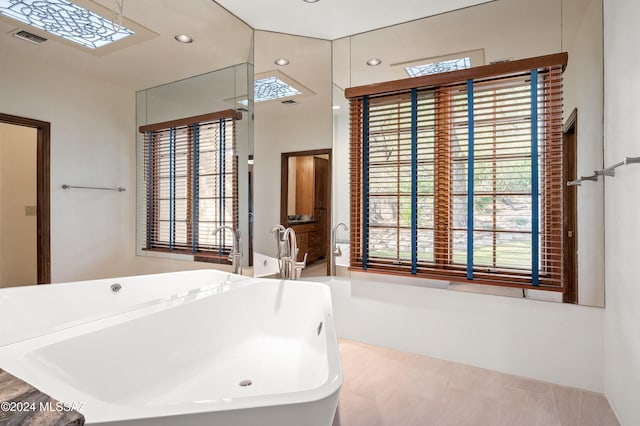 full bath featuring recessed lighting, a freestanding tub, and visible vents