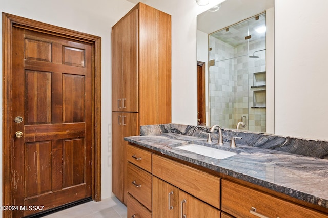 full bathroom with a stall shower, tile patterned flooring, and vanity