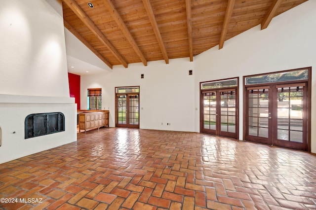 unfurnished living room with brick floor, wood ceiling, a fireplace, and french doors