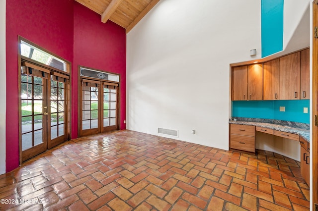 interior space with visible vents, wood ceiling, brick floor, french doors, and built in desk