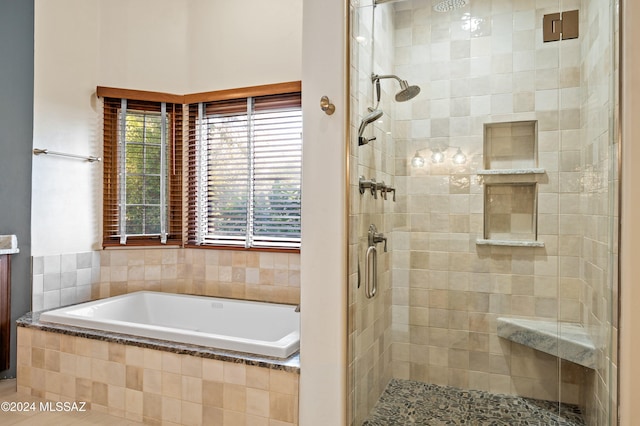 full bathroom with a garden tub and a shower stall