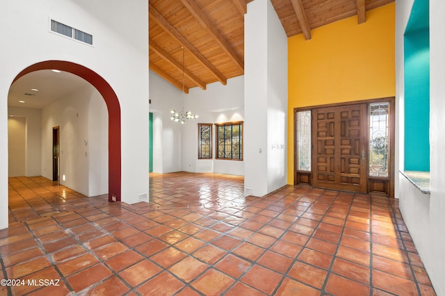 tiled foyer entrance with wood ceiling, visible vents, and beamed ceiling