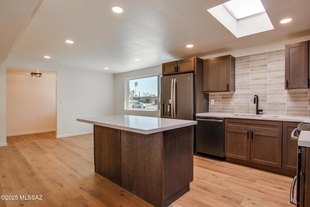 kitchen with light wood-type flooring, a sink, dishwasher, and stainless steel fridge with ice dispenser