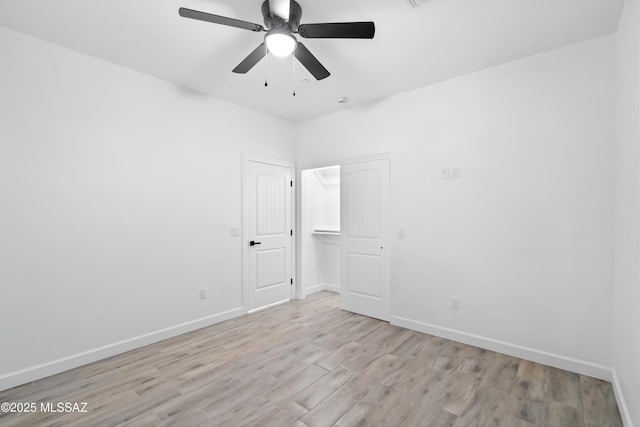 unfurnished room with light wood-type flooring, baseboards, and a ceiling fan