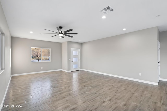 spare room with recessed lighting, visible vents, ceiling fan, wood finished floors, and baseboards