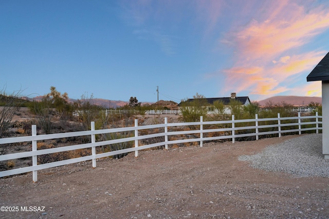 yard at dusk featuring fence