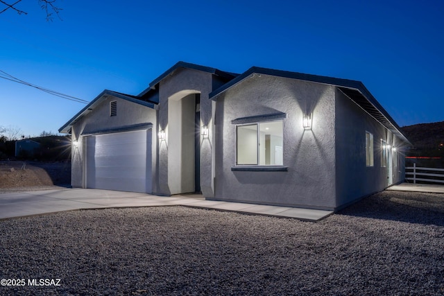 single story home with an attached garage, driveway, and stucco siding