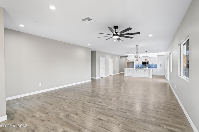 unfurnished living room with ceiling fan, light wood finished floors, visible vents, and recessed lighting