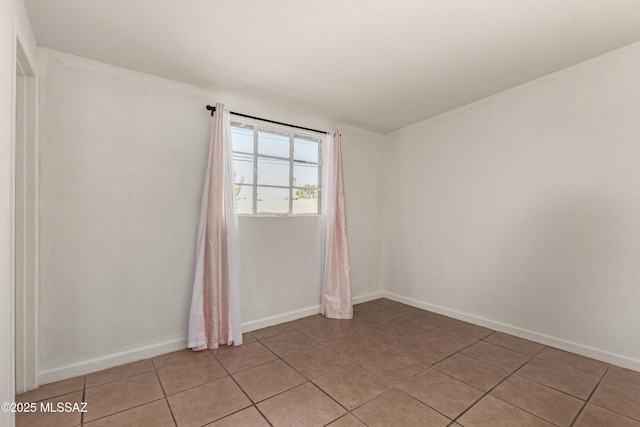 unfurnished room with baseboards and light tile patterned floors