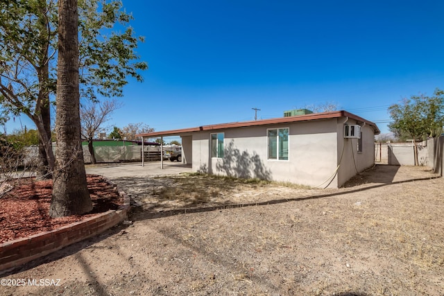 rear view of property with fence and stucco siding