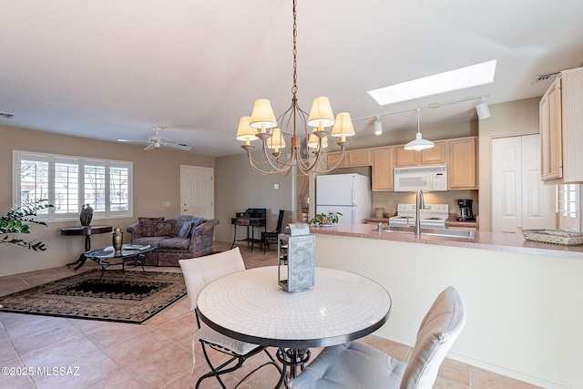 dining room featuring ceiling fan, visible vents, a skylight, and light tile patterned flooring