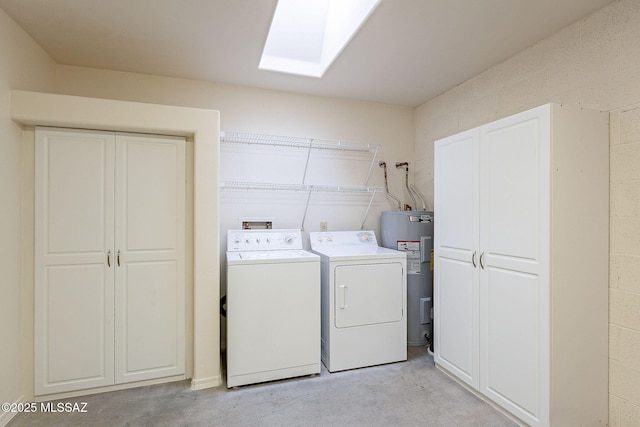 washroom with a skylight, laundry area, washing machine and clothes dryer, and electric water heater