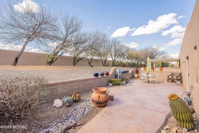 view of patio with outdoor dining space, a fenced backyard, and a pergola