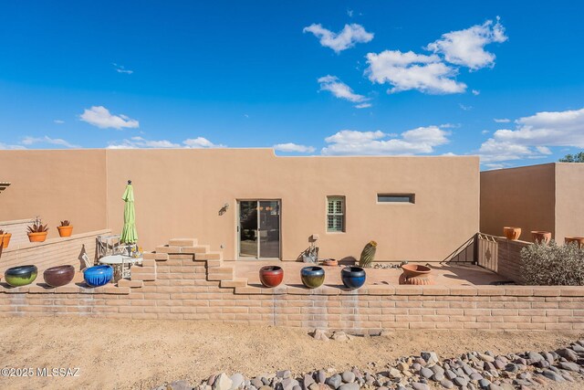 back of property featuring a patio and stucco siding