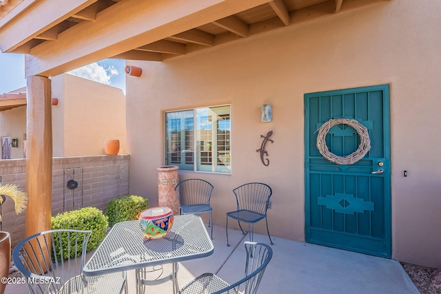 doorway to property featuring a patio area and stucco siding