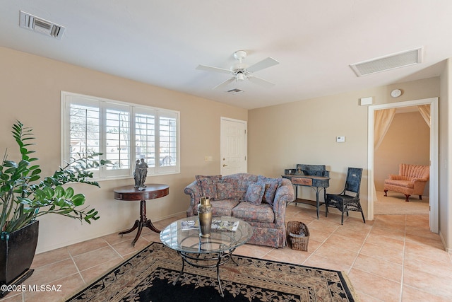 tiled living area featuring a ceiling fan, visible vents, and baseboards