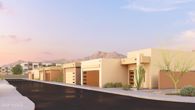 view of front of house featuring a garage, a mountain view, and stucco siding