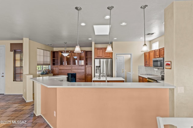 kitchen with stainless steel appliances, light countertops, brown cabinetry, and tasteful backsplash