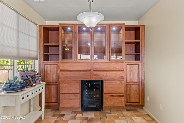 living room featuring wine cooler, stone finish floor, and baseboards