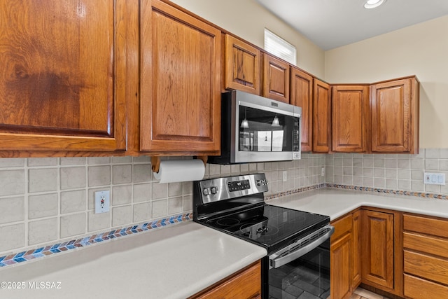 kitchen featuring appliances with stainless steel finishes and brown cabinetry