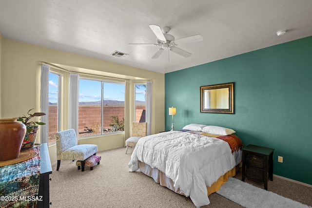 carpeted bedroom featuring a ceiling fan, visible vents, and baseboards