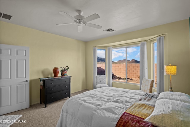 carpeted bedroom featuring a ceiling fan and visible vents