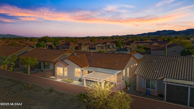 aerial view at dusk featuring a residential view and a mountain view