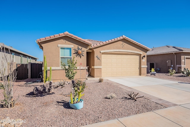 mediterranean / spanish home with a garage, fence, a tile roof, concrete driveway, and stucco siding