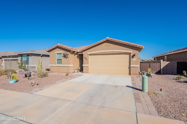 view of front of house with a garage, fence, a tiled roof, driveway, and stucco siding