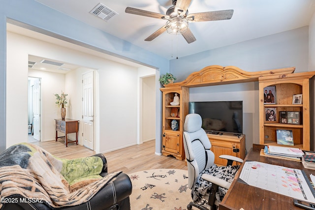 home office featuring light wood-type flooring, visible vents, and ceiling fan