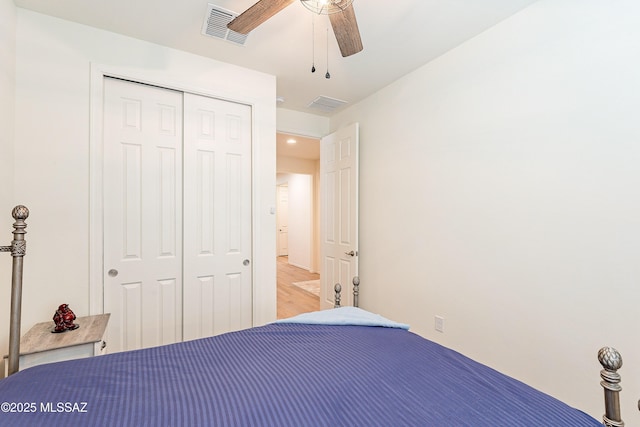 unfurnished bedroom featuring light wood-style floors, a ceiling fan, visible vents, and a closet