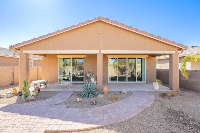 back of property featuring a patio, fence, and stucco siding