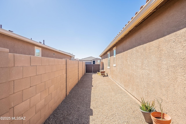 view of side of property featuring a fenced backyard and stucco siding