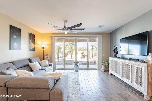 living area featuring ceiling fan, visible vents, and wood finished floors