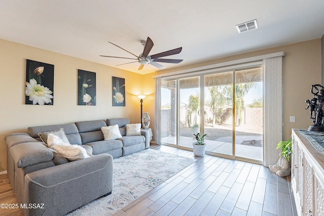 living room with visible vents, ceiling fan, and wood finished floors