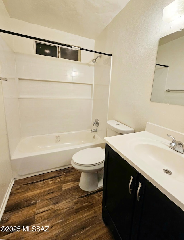 bathroom with toilet, tub / shower combination, wood finished floors, and vanity