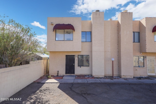 view of front of house with fence and stucco siding