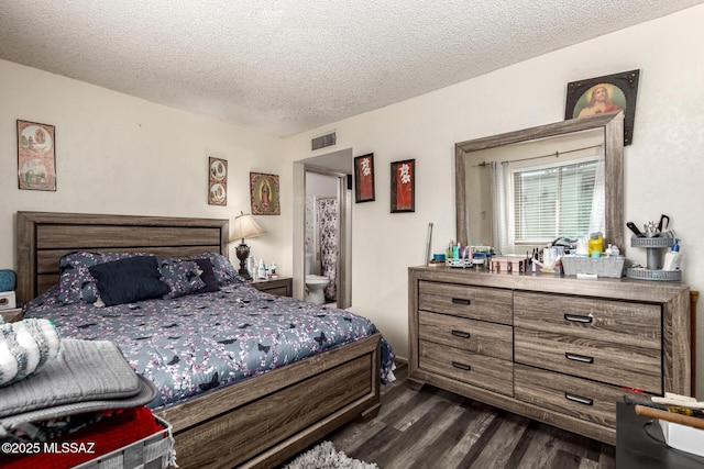 bedroom with visible vents, dark wood finished floors, and a textured ceiling