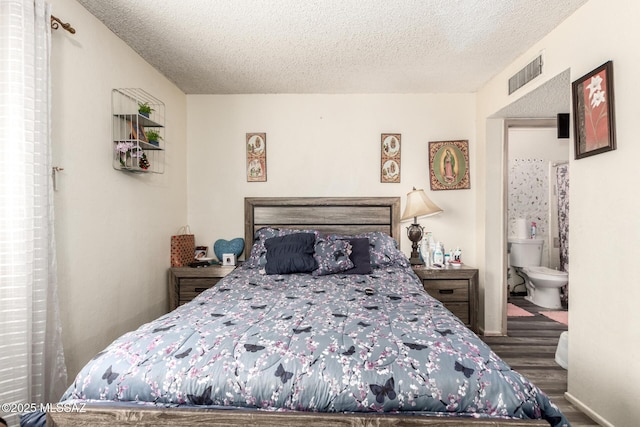 bedroom featuring a textured ceiling, wood finished floors, and visible vents