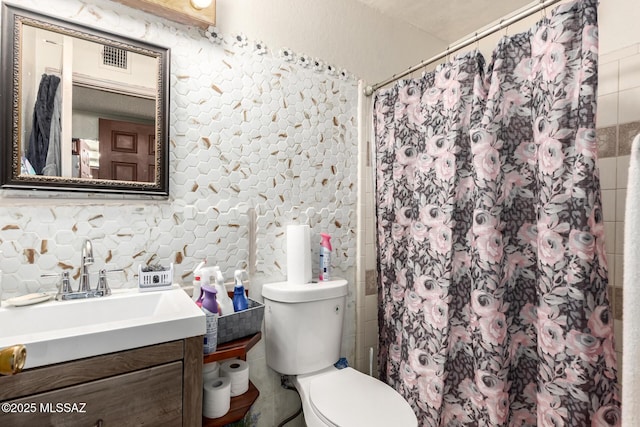 bathroom featuring visible vents, a shower with shower curtain, vanity, and toilet