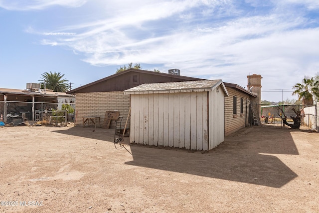 view of side of home with brick siding and fence