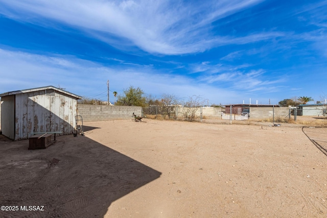 view of yard featuring a storage shed, a fenced backyard, and an outdoor structure